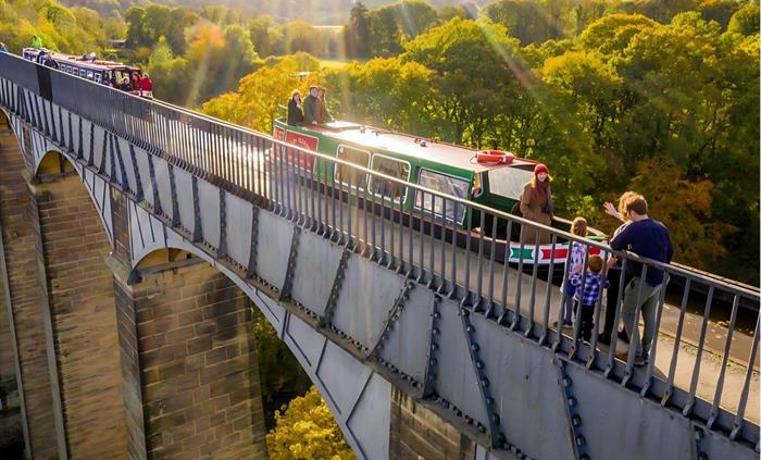 An aerial view of motorised canal boats crossing the iconic Pontcysyllte Aqueduct.